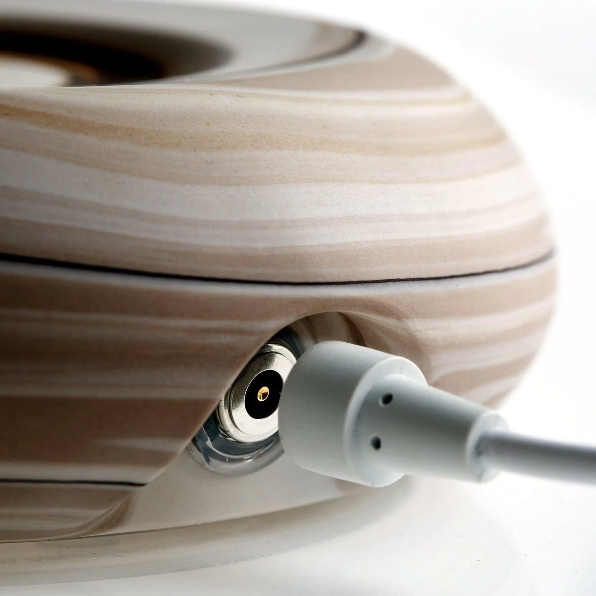 A white plug entering a Mayu Swirl Earth socket