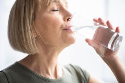 A woman drinking a glass of water.