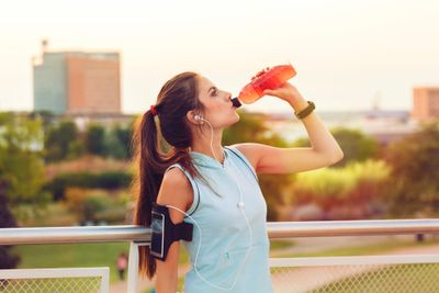 A woman addressing her mineral deficiency with a sports beverage
