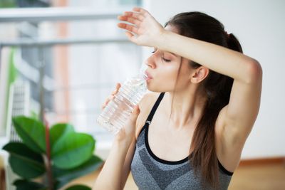 Woman drinking electrolyte water to fight dehydration after a workout