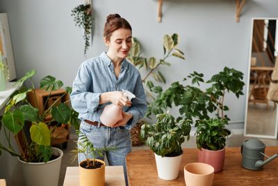 Woman watering her potted plants with structured water
