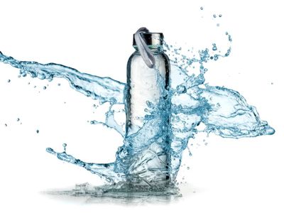 Glass water bottle and water splash