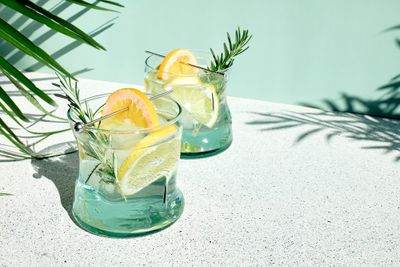 Two glasses filled with lemon slices and water that are good for the liver.