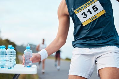 A man holding a bottle of water while running.
