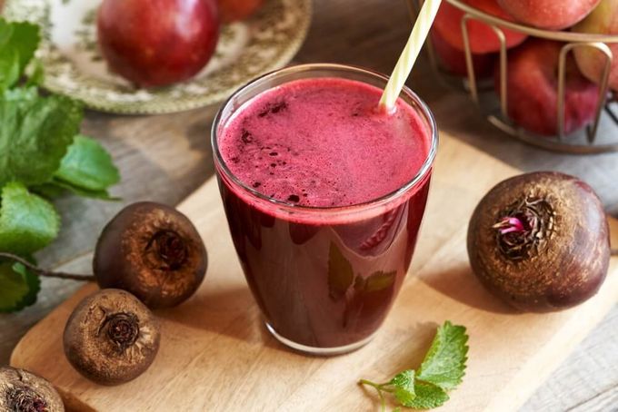 A beet root drink on a table surrounded by the vegetable that's considered good for liver health.