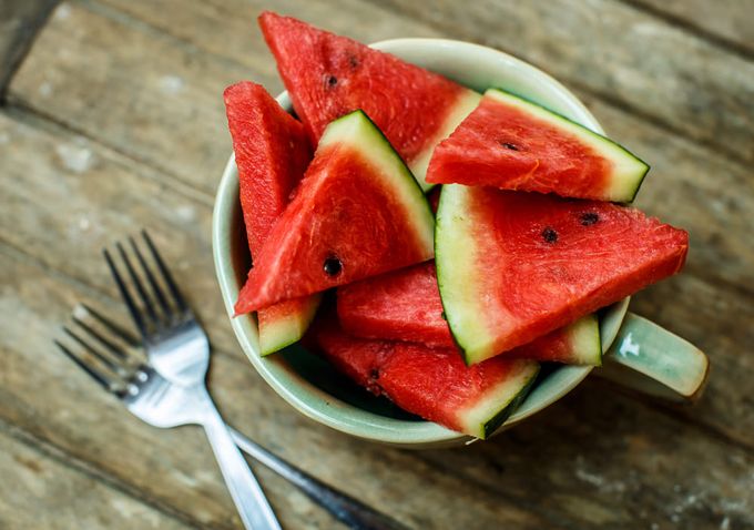 A bowl filled with electrolyte boosting watermelons next to a couple of forks.