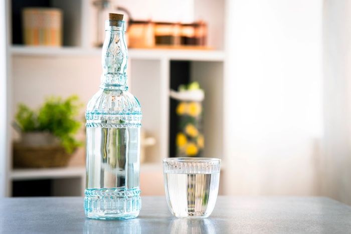 Glass bottle with water and glass