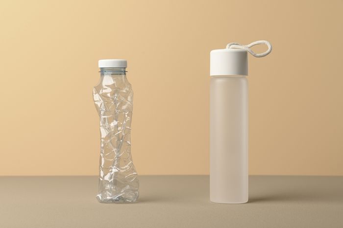 A glass water bottle and a plastic bottle compared side by side