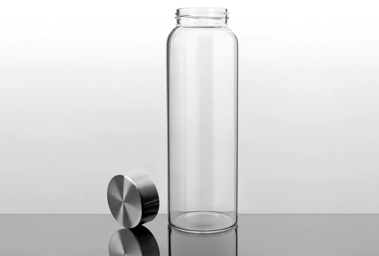 a glass bottle with a metal lid next to it